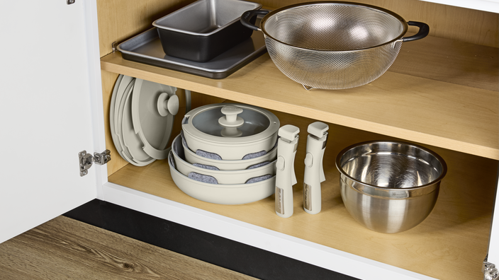 detachable cookware stacked in a cabinet
